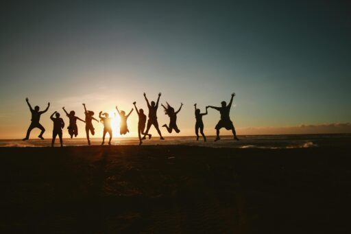 Smuk solopgang der nydes ag en gruppe unge mennesker, der hopper af begejstring
